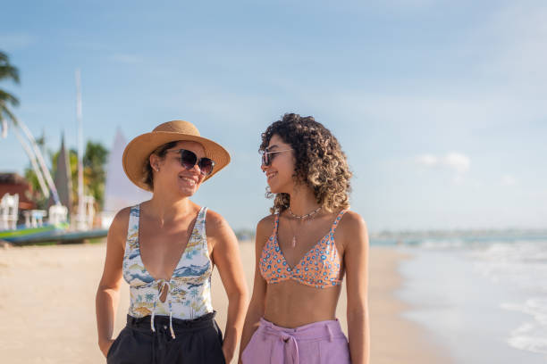 istock Mother and daughter walking along the beach 1402204539