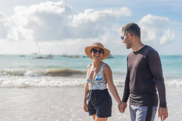 istock Tourist couple walking on the beach 1402204572