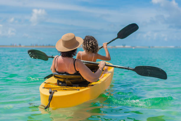 grandma and granddaughter with kayak on the beach - beach nautical vessel party clothing imagens e fotografias de stock