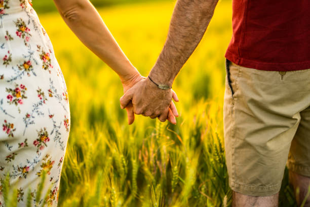 istock Couple holding hands on a barley field. 1402204628