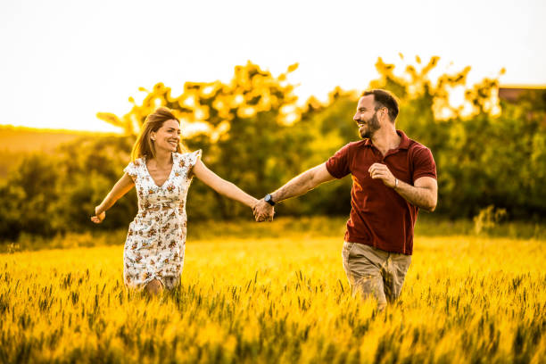 istock Happy couple running on a golden field. 1402204681