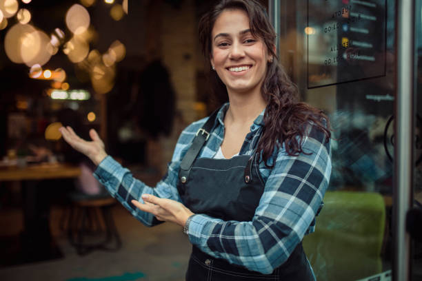 istock A beautiful waitress with an apron greets restaurant guests and welcomes them. 1402206123