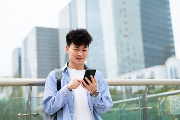 istock Asian young handsome university student in city street 1402211558