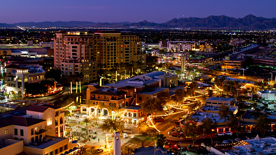 Aerial establishing shot of the 5th Avenue Shopping District in Old Town Scottsdale, Arizona at twilight. \n\nAuthorization was obtained from the FAA for this operation in restricted airspace.