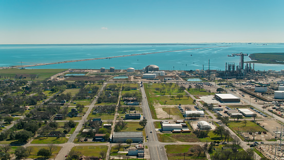 Aerial shot of a road dividing a residential neighborhood from petrochemical plants and petroleum refineries in Texas City, in the Houston metropolitan area on Galveston Bay.