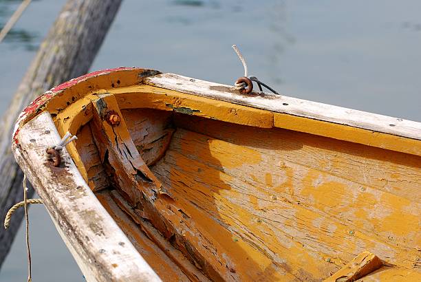 istock Worn-out wooden rowboat moored to post 140222099