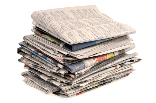 Close-up stack of newspapers on a white background