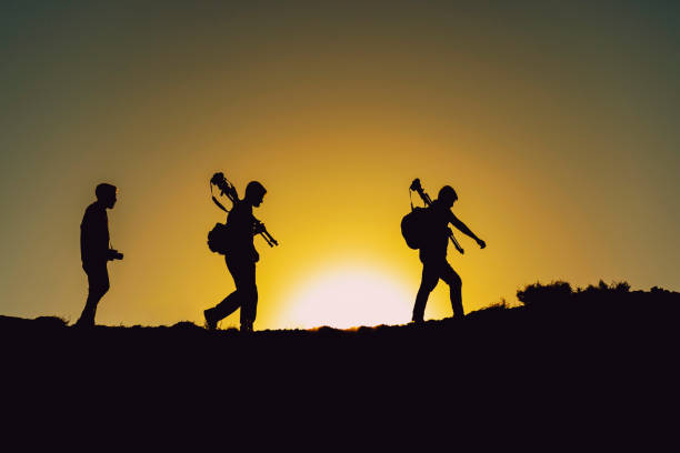 team of photographers walking in nature at morning sunrise time stock photo