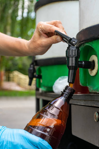 istock Woman pours beer into a plastic bottle 1402246960