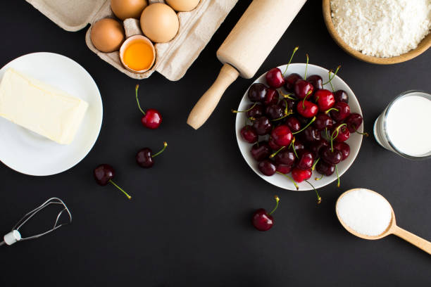 istock Top view of ingredients for making cherry pie or cake on the black background. Copy space. 1402251366