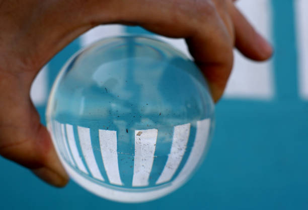 istock hand holding a glass lens ball 1402251525