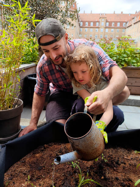 istock Fatherhood: dad and daughter planting flowers 1402251684