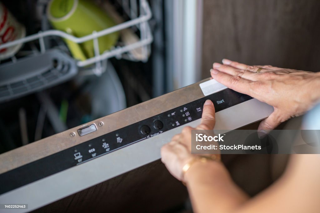 Close-up of woman setting cycle on dishwasher Close-up of female hand setting cycle on dishwasher Dishwasher Stock Photo