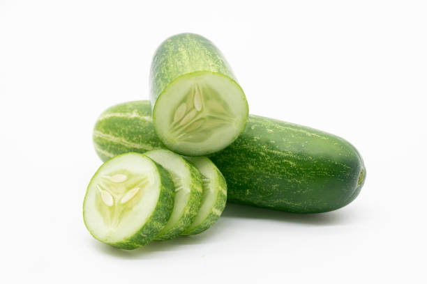 istock whole cucumber with some pieces isolated on white background. 1402255062