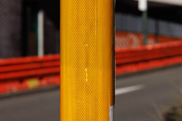 Yellow reflective metal street pole.