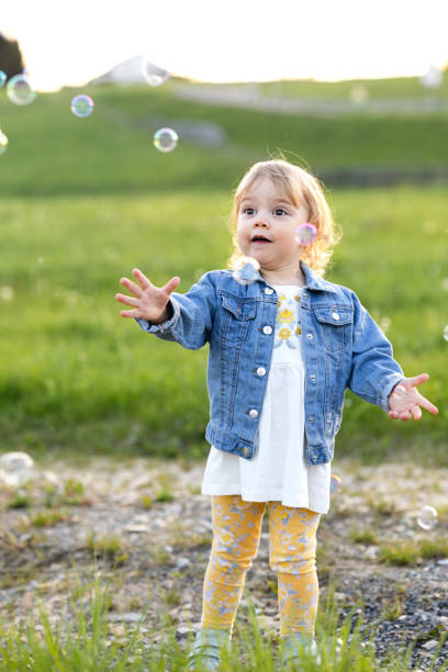 istock A girl degass in a meadow and catches soap bubbles 1402265350