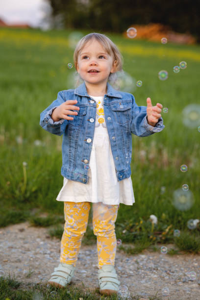 istock A girl degass in a meadow and catches soap bubbles 1402265508
