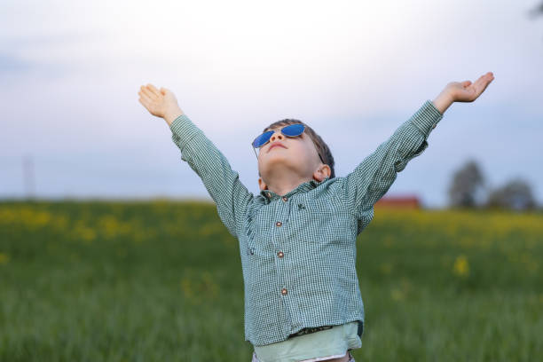 istock boy playing in a green meadow with yellow flowers 1402266510