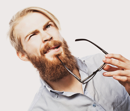 Young bearded hipster man wearing eyeglasses. Over white background.