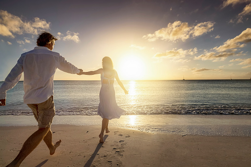 Silhouette of couple on beach at dusk under a spectacular sky