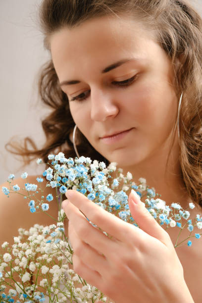 young happy woman in dress posing with flowers smiling
