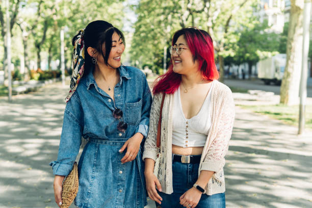 istock Japanese girlfriends walking and talking in park 1402273337
