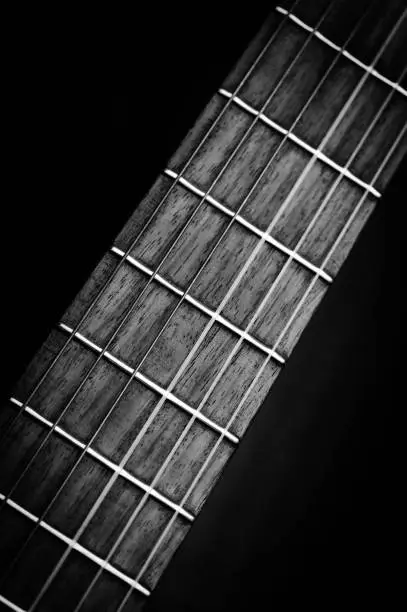 Photo of Classical acoustic guitar fretboard in black and white.