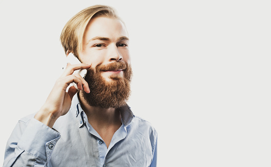 tehnology, internet, emotional and people concept: young bearded man talking on mobile isolated on white background.Special Fashionable toning.