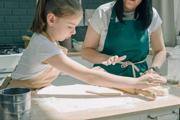 istock Mother and daughter preparing dough at home together 1402276994