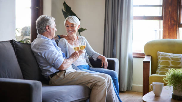 istock Smiling senior couple toasting each other with wine on their sofa 1402277184