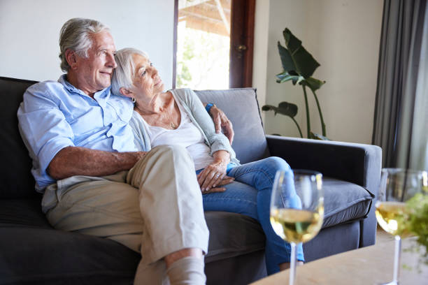 istock Loving senior couple drinking wine while relaxing on their sofa at home 1402278340