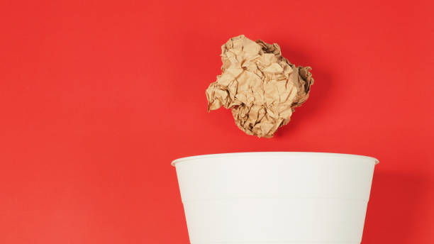 istock The crumpled white papers is mauled and a trash can on red background. 1402281632