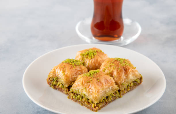 istock Pistachio baklava on a white plate with Turkish tea.A plate baklava on white background 1402283603