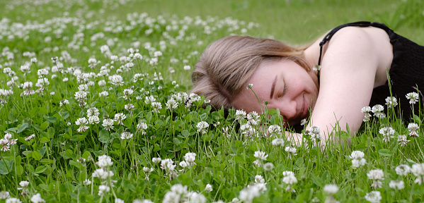 Woman laying on green grass and smiling