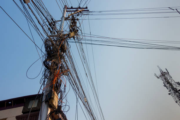 istock Electricity poles with overcrowded wires and distribution box in India. 1402284305