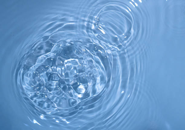 istock Circles on water. Blue round shadows. Blurred background made with water and light in monochrome. 1402284352
