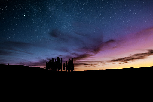 Val d'Orcia at night against starry moody sky. Italy, Tuscany