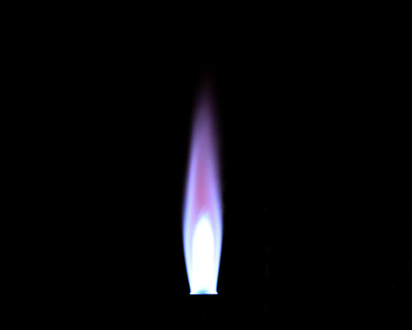 The flame from a Bunsen burner used in the laboratory, photographed in the dark