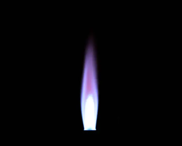 Photo of The flame from a Bunsen burner used in the laboratory, photographed in the dark