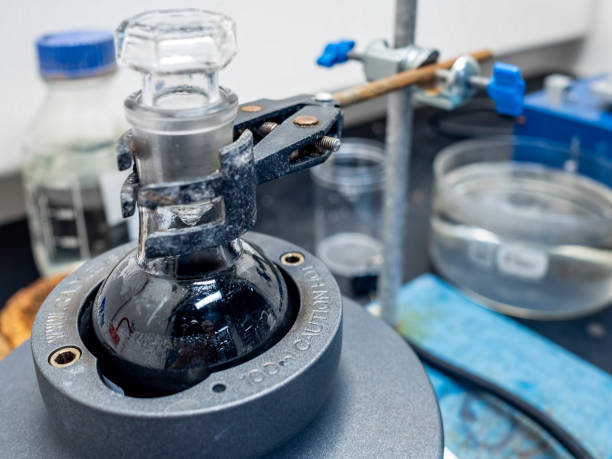 Chemical reaction mixture in a round-bottom flask Chemical reaction mixture in a round-bottom flask under low temperature with continuous stirring. The flask sits inside a metallic heating mantle. Entire apparatus located in a safety fume cupboard. fume cupboard stock pictures, royalty-free photos & images