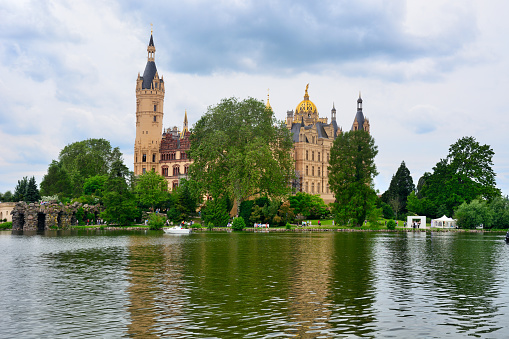 Schwerin cathedral St. Marien and St. Johannis, one of the earliest large examples of brick gothic architecture, seen from the lake shore in the state capital city of Mecklenburg Vorpommern, Germany, blue sky with copy space, selected focus