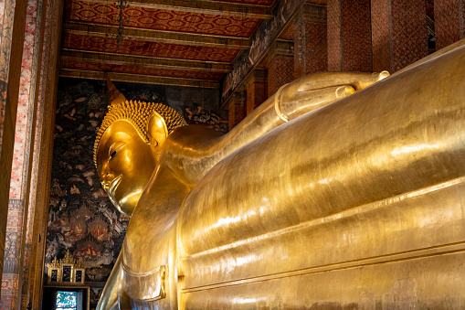 Reclining Buddha statue in Wat Pho, a famous Buddhist temple complex in Bangkok, Thailand.