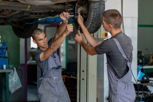 istock Teenagers changing car shock absorbers. 1402301089