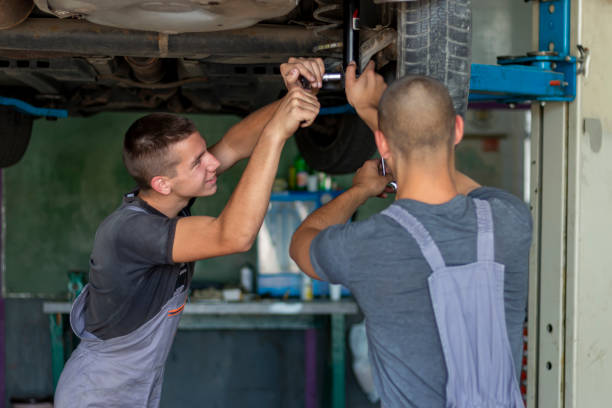 istock Teenagers changing car shock absorbers. 1402301090
