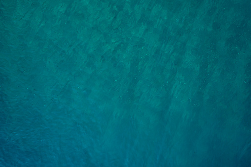 Shining blue water ripple background. Surface of water in swimming pool.