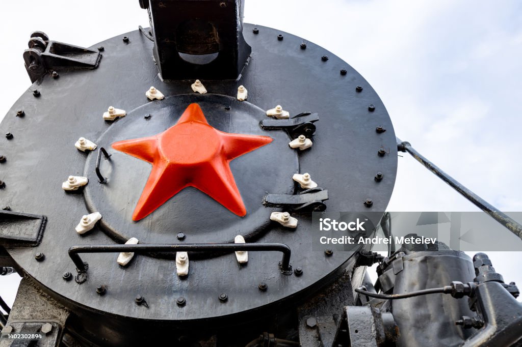 frontal part of an old black steam locomotive with a red star frontal part of an old black steam locomotive with a red star. red star on an old train Black Color Stock Photo