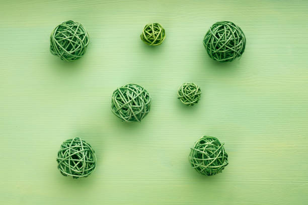 seven wicker green balls on a green surface. balls of different sizes are placed randomly