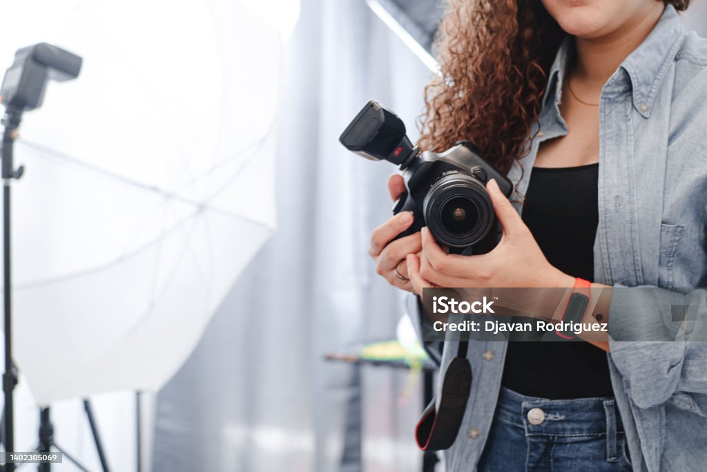 unknown photographer woman holding a professional camera on the studio. Photographer Stock Photo