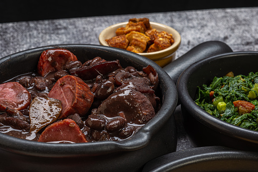FEIJOADA: typical and traditional food of Brazilian cuisine, served with rice, farofa, orange, pepper and cabbage.