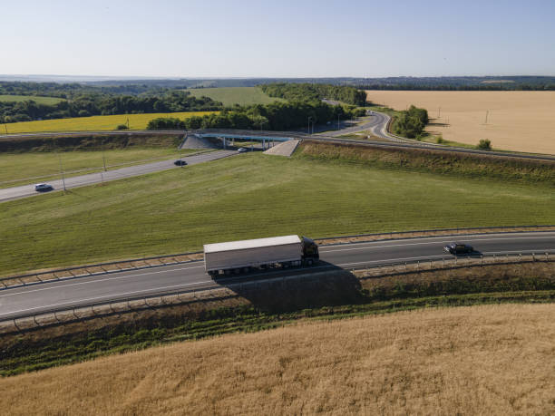 istock Truck with Cargo Semi Trailer Moving on Summer Road. Aerial Top View. White vehicle 1402306708